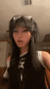 a woman with long black hair is wearing sunglasses and a black tank top .
