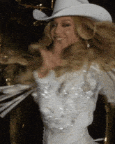 a blonde woman wearing a white cowboy hat and a white dress