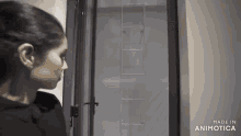a woman is standing in front of a door with the words made in animatica on the bottom