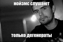 a man with a beard is holding a gun in a black and white photo with a caption in russian .