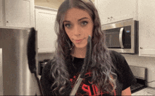 a woman in a black shirt that says sin holds a knife