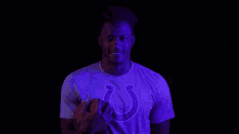 a man wearing a purple shirt with a horseshoe on it