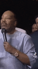 a man is holding a microphone in his hand while talking into it .