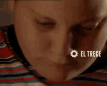 a close up of a child 's face with the words `` el trece '' on the bottom .