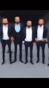 a group of men in suits are standing in a row with their faces obscured