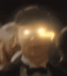 a man in a tuxedo and bow tie has his eyes glowing brightly