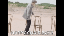 a man is standing in front of a row of chairs in the dirt .