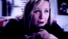 a close up of a woman 's face with a tear running down her face .