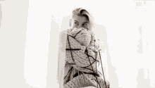 a black and white photo of a woman wrapped in a scarf .