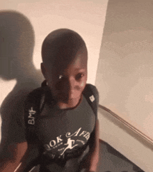 a young boy wearing a black shirt that says ok africa on it