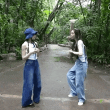 two women are standing next to each other on a road .