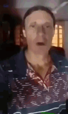 a man is making a funny face in a blurry photo .