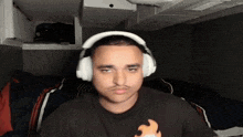 a man wearing headphones and a black shirt is sitting in a room .