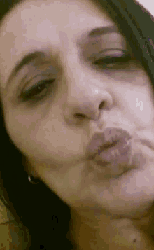 a close up of a woman making a kiss with her lips
