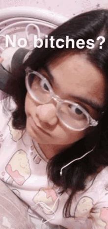 a girl wearing glasses and headphones is taking a selfie while laying on a bed .