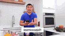 a man in a blue shirt is holding a cell phone with the username knorrlexvanjo21 on the screen