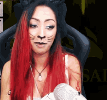 a woman with red hair and a cat face paint