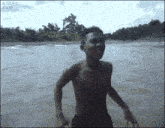 a shirtless boy is jumping into a river with a 4gifs.com watermark