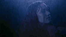 a close up of a woman 's face in the rain with water drops on her face .