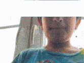 a close up of a child 's face with a green shirt