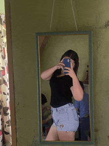 a woman taking a selfie in a mirror with her phone