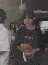 a boy wearing a hybs t-shirt holds a stuffed animal