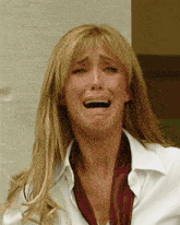 a woman in a white shirt and red scarf is crying with her mouth open
