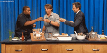 three men are toasting in front of a kitchen counter with a cookbook on it that says " resh and easy "