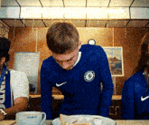 a man wearing a blue nike shirt with a chelsea logo on it