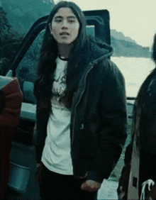 a man with long hair is wearing a black jacket and a white shirt