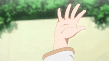 a person 's hand is reaching out towards the camera .