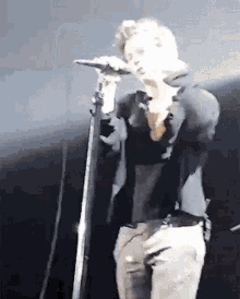 a man is singing into a microphone on stage .