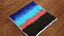 a painting of a sunset with blue red and black paints