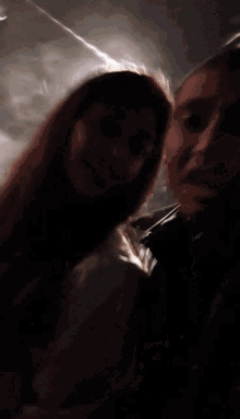 a man and a woman are kissing in a dark room with the sun shining through the window