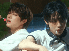 two young men are dancing and one is holding a lollipop
