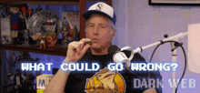 a man sitting in front of a microphone with the words what could go wrong dark web on the screen