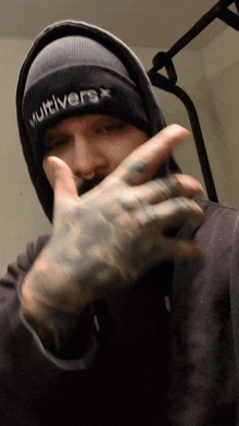 a man wearing a black beanie that says multiverse on it