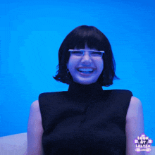 a woman wearing glasses is smiling and holding a video game controller in front of a blue background that says look at lolisa on it