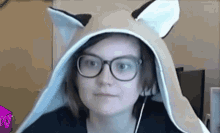 a woman wearing glasses and a hat with fox ears is looking at the camera