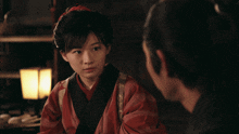 a woman in a red kimono stands next to a man with a bald head