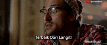 a man wearing glasses and a plaid shirt says terbaik dari langit !