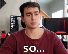 a man in a maroon shirt with the word so on his chest