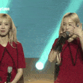 two women singing into microphones with the word toon in the corner