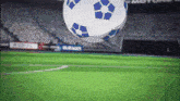 a blue and white soccer ball flies through the air