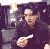 a man in a striped suit is holding a piece of paper