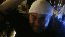 a man with a bandage on his head is standing in front of a bar with bottles of vodka