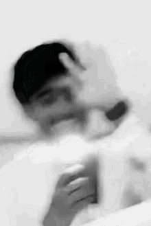 a blurry black and white photo of a man taking a selfie .