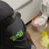 a person wearing a black shirt that says fresh is sitting in a toilet .