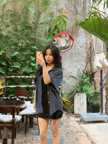 a woman taking a picture of herself with a cell phone