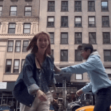 a man and a woman are dancing in front of a building that says tery